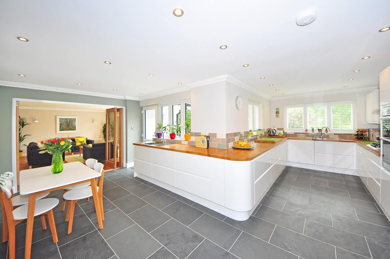 A large kitchen and dining room with wooden countertops and slate grey floors